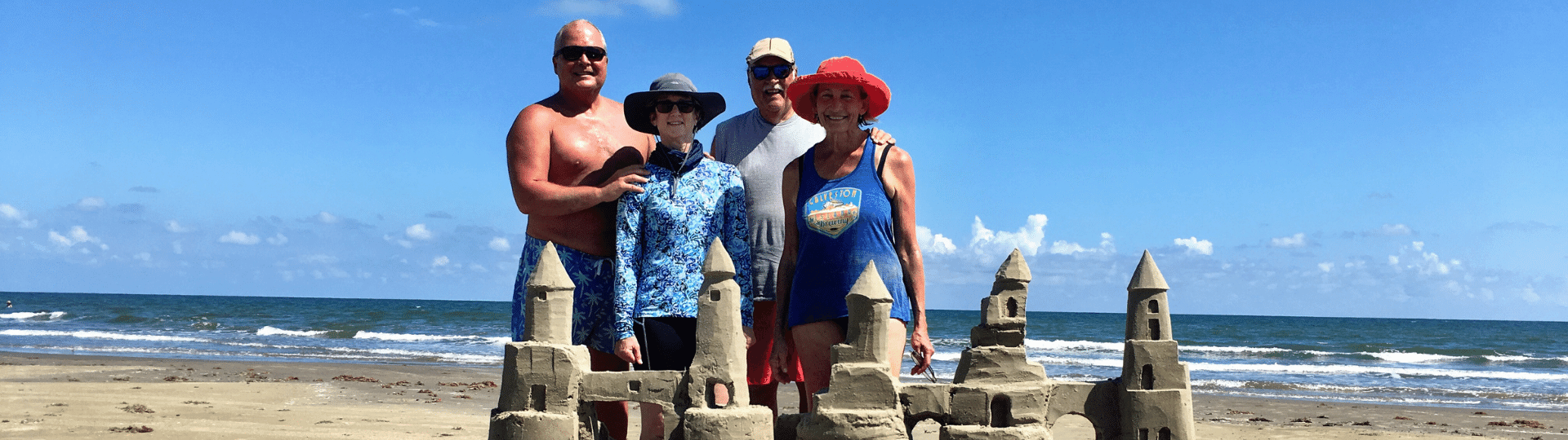 Family standing in front of sand castle in Galveston tx