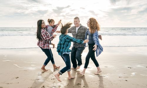 Family in fall clothing hugging on the beach